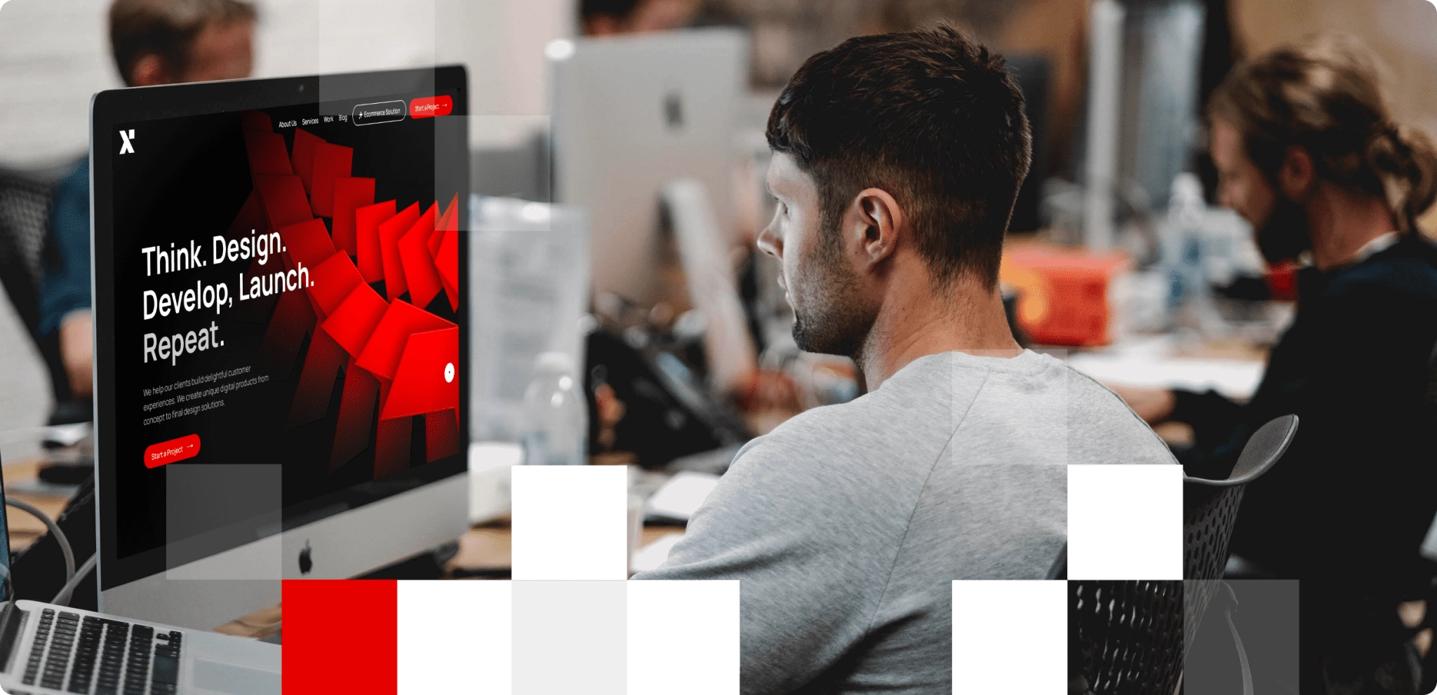 A man sitting in front of a computer in a UI UX design company